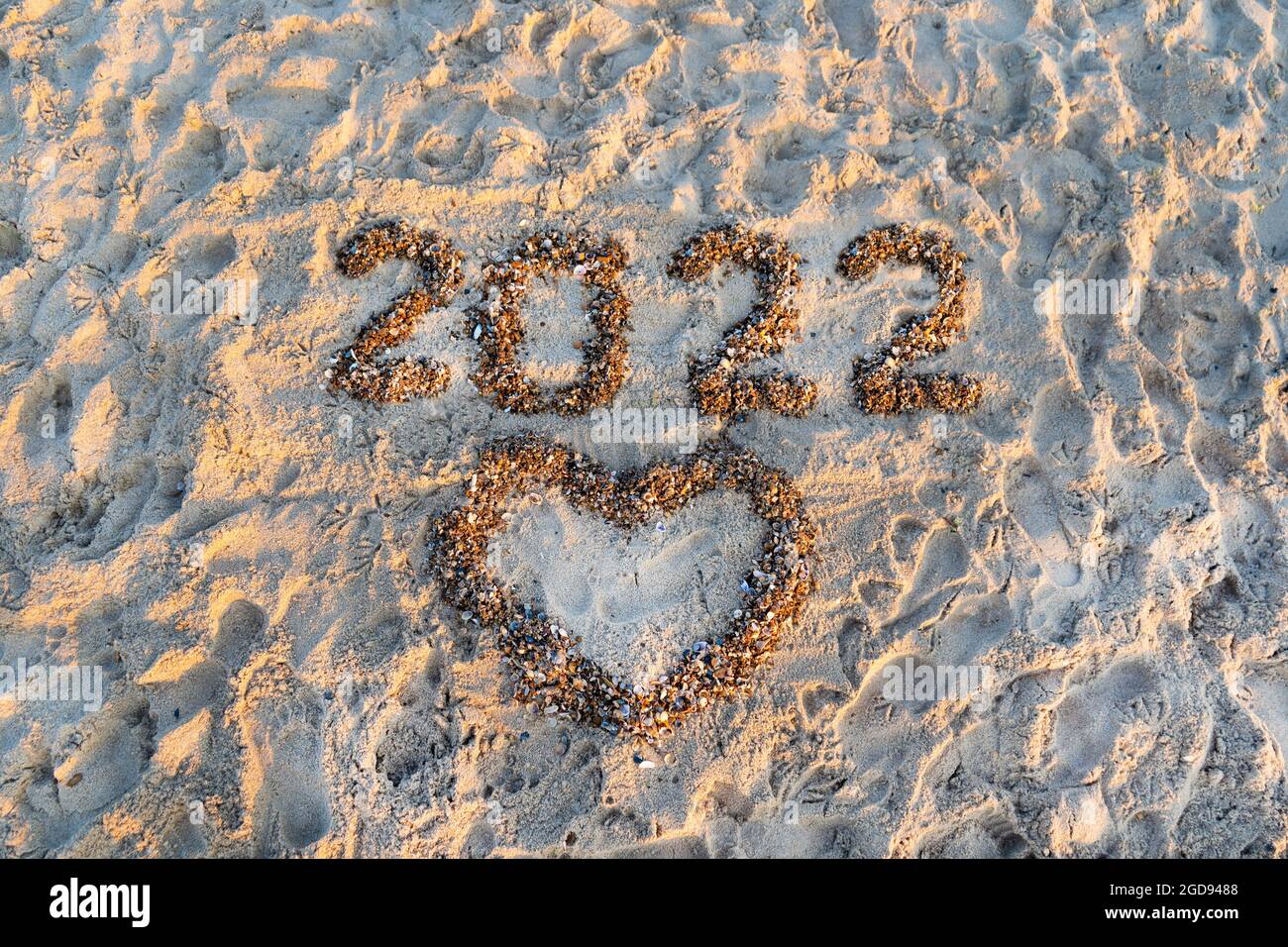 Die Nummern 2022 liegen an einem sandigen Strand mit Muschelschale ...
