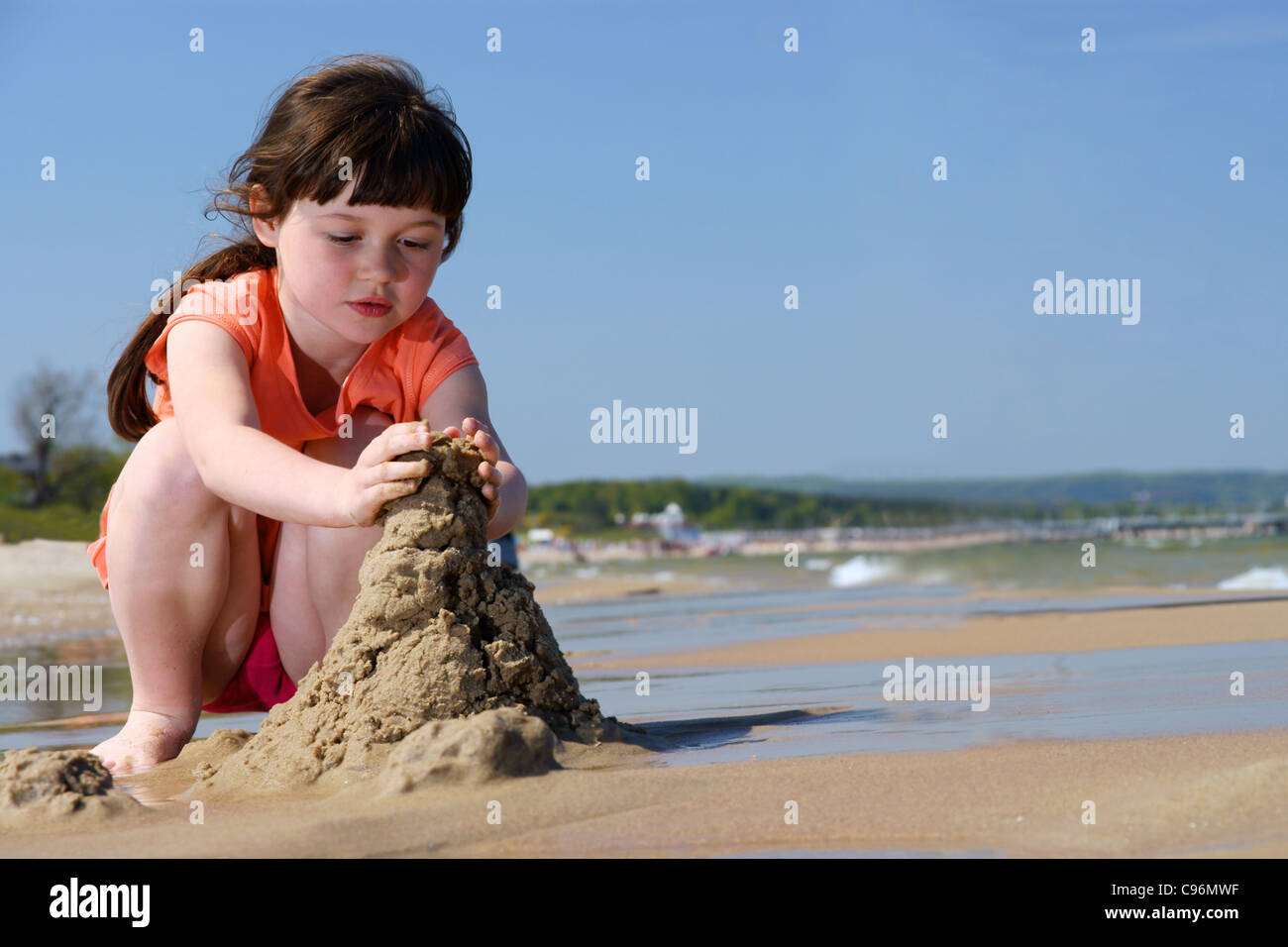 Kinder am Strand, junge Mädchen spielen In den Sand, Sandburgen zu