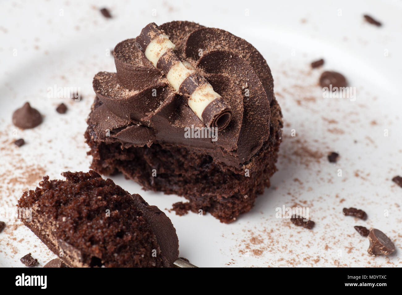 Chocolate Cupcake auf weißer Teller mit Gabel, bestäubt mit Kakao und ...